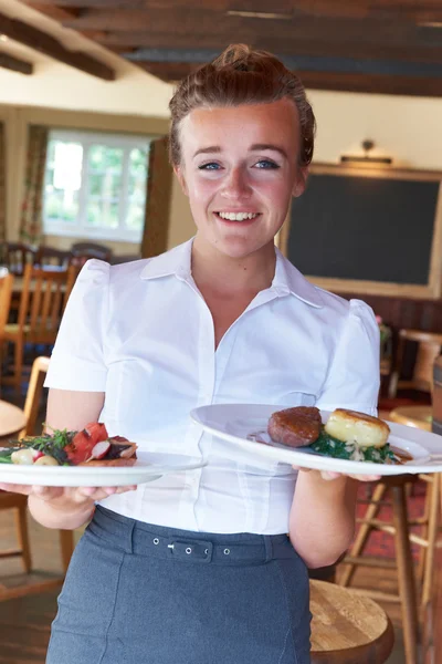 Portrait Of Waitress Serving Food In Restaurant