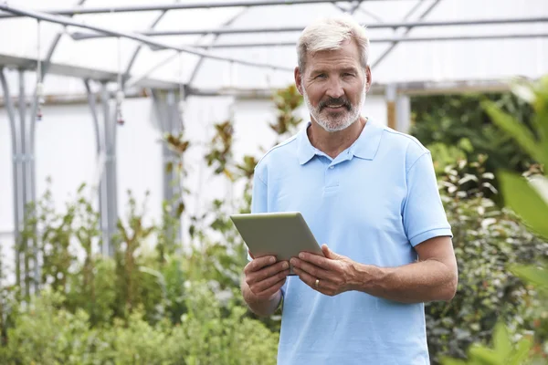 Portrait Of Sales Assistant In Garden Center With Digital Tablet