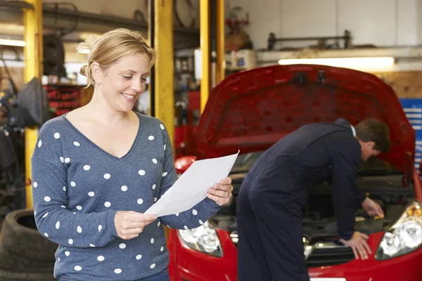 Happy Woman With Garage Repair Bill
