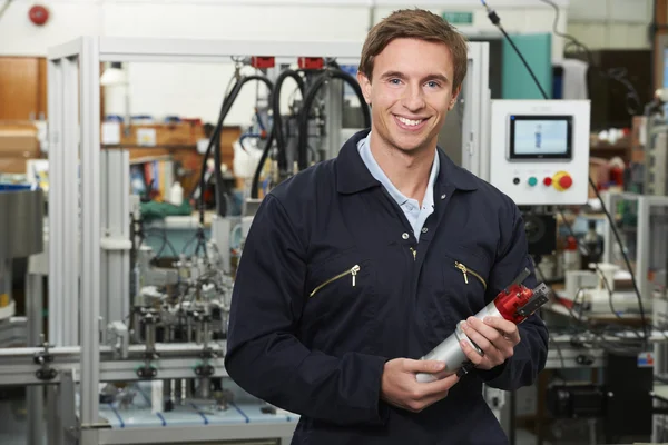 Portrait Of Engineer Holding Component In Factory