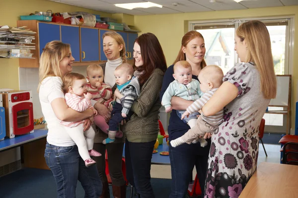 Group Of Mothers With Babies Meeting At Playgroup