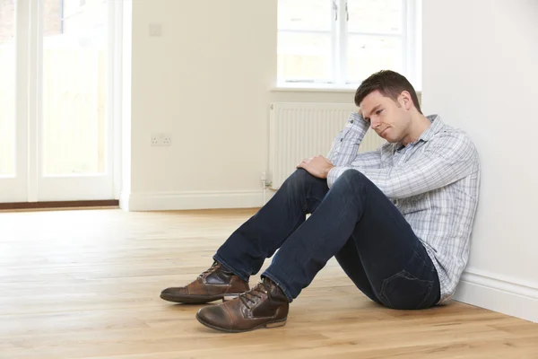 Depressed Man Sitting In Empty Room Of Repossessed House