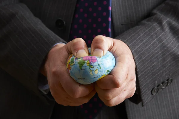 Businessman Squeezing Globe Over Asia