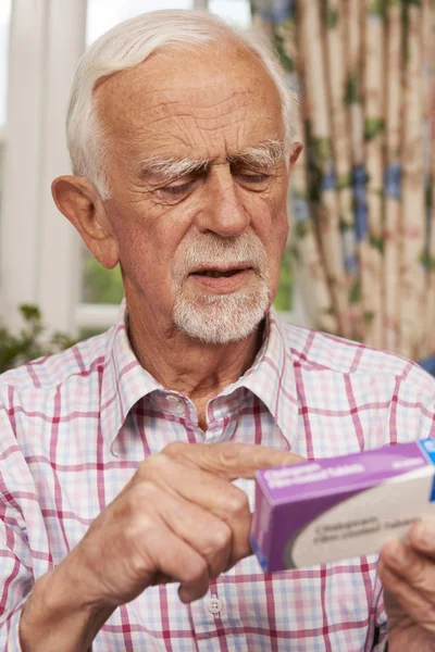 Senior Man Reading Instructions On Medication