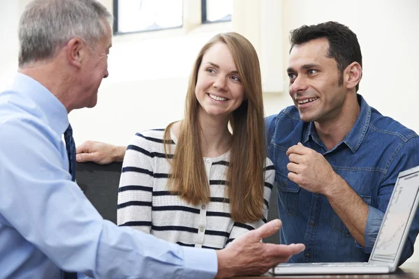 Couple Talking With Financial Advisor In Office