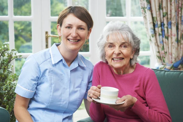 Senior Woman At Home With Carer