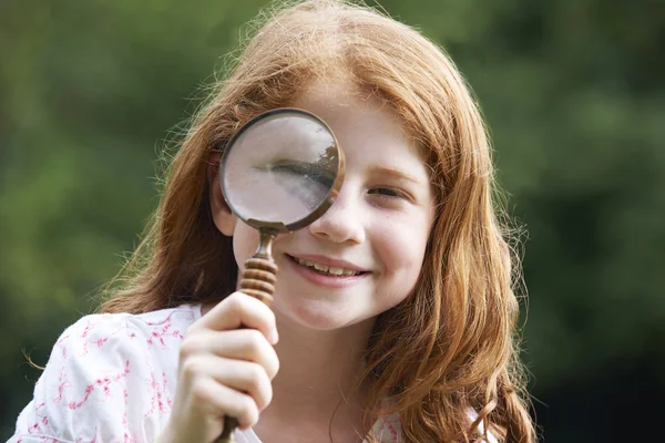 Girl Looking Through Magnifying Glass With Magnified Eye