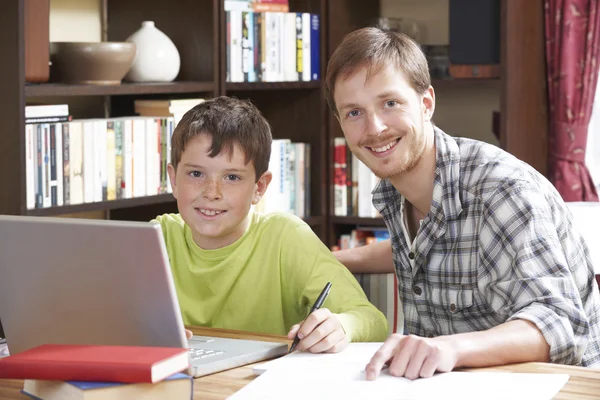 Boy Working At With Tutor At Home