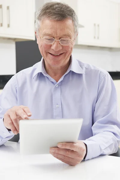Senior Man Using Digital Tablet At Home