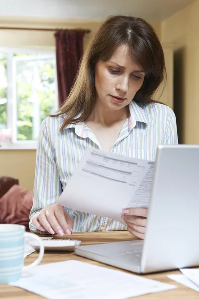 Worried Middle Aged Woman Looking At Household Finances