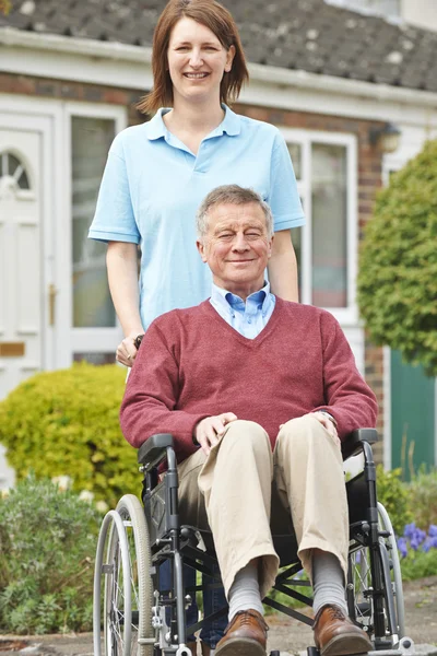 Carer With Senior Man In Wheelchair