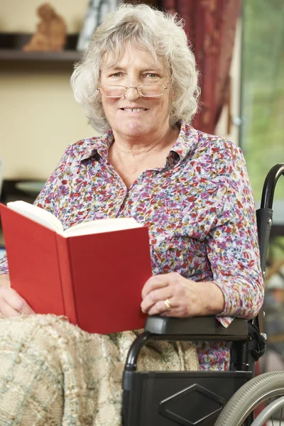 Senior Woman In Wheelchair Reading Book