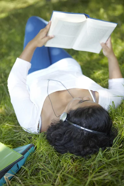 Carefree Student Revising And Listening To Music In Park