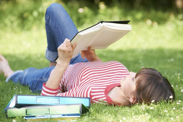 Female Student Reading Textbook In Park