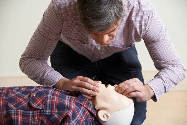 Man In First Aid Class Performing Mouth To Mouth Resuscitation O