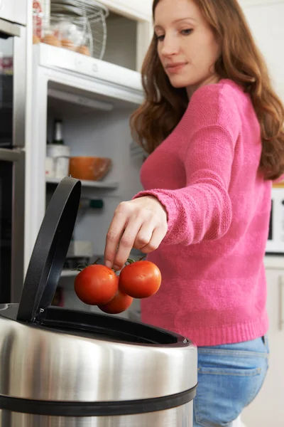 Woman Throwing Away Out Of Date Food In Refrigerator