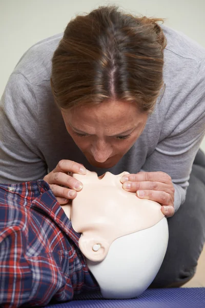 Woman In First Aid Class Performing Mouth To Mouth Resuscitation