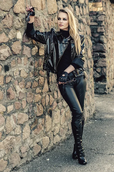 Fashion model wearing leather pants and jacket posing