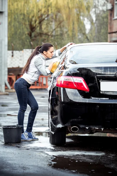 Girl washes the car