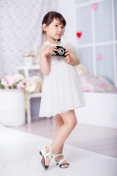 Little girl holding an old camera