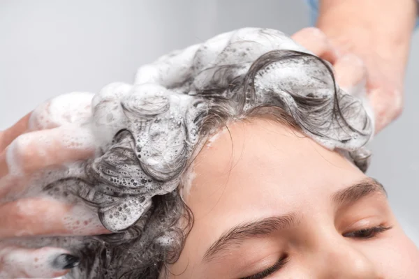 Hair washing at a hairdressing salon, young little girl