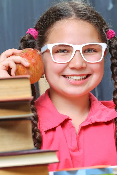 Happy school girl in front of the blackboard