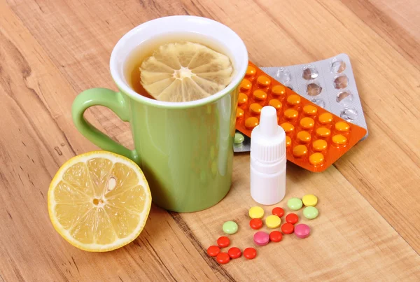 Pills, nose drops and hot tea with lemon for colds, treatment of flu and runny