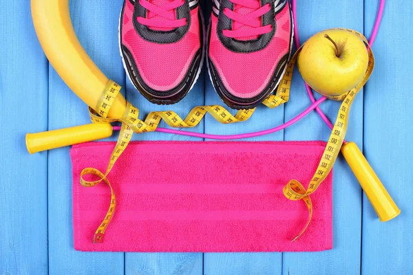 Pair of sport shoes, fresh fruits and accessories for fitness on blue boards, copy space for text