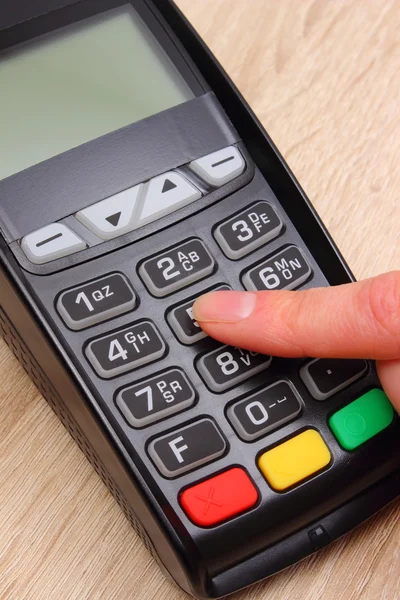 Hand of woman using payment terminal, enter personal identification number