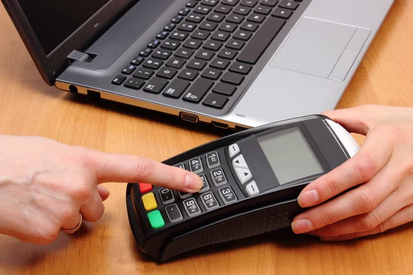 Hand of woman using payment terminal, enter personal identification number
