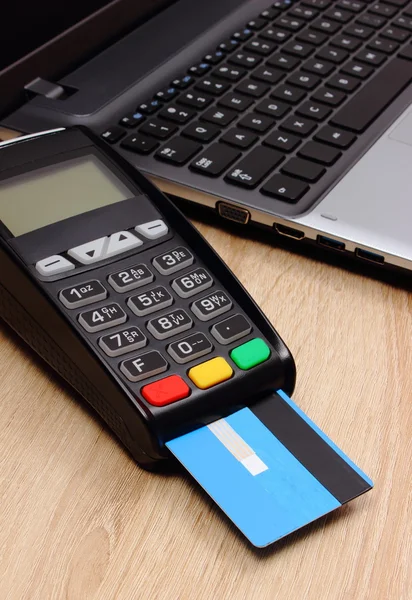 Payment terminal with credit card and laptop, finance concept