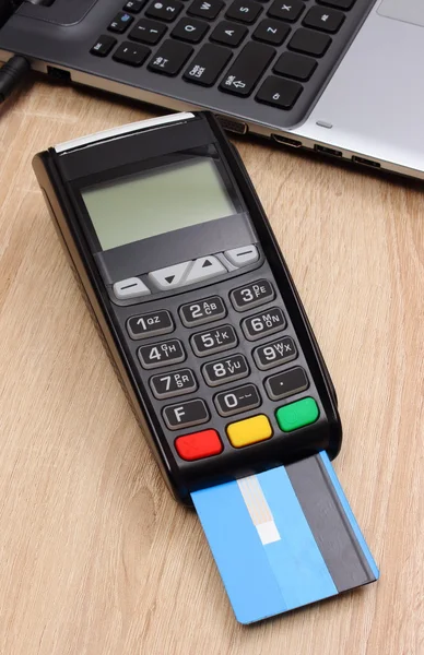Payment terminal with credit card and laptop, finance concept