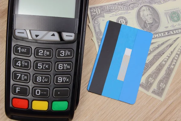 Payment terminal with credit card and money on desk, finance concept