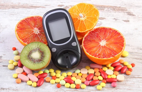 Glucometer, fruits and colorful medical pills, diabetes, healthy lifestyle and nutrition