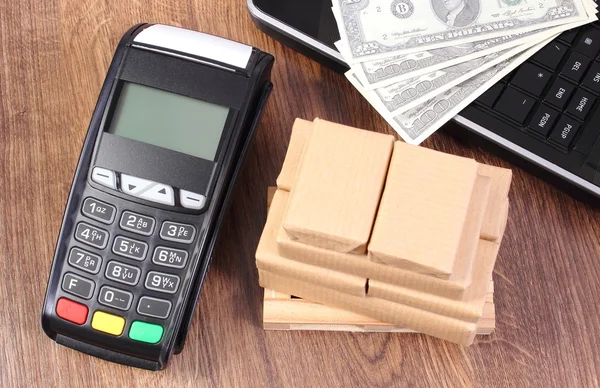 Payment terminal with currencies dollar, laptop and boxes on pallet, paying for shipping and products