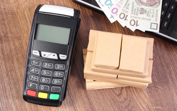 Payment terminal with polish money, laptop and boxes on pallet, paying for shipping and products