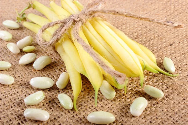Seeds and stack of yellow beans on jute canvas, healthy food