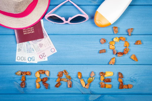 Word travel with shape of sun, sunglasses, sun lotion, straw hat, passport with polish money