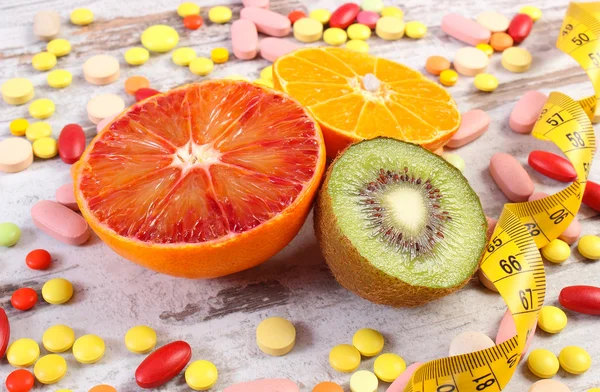 Natural fruits, centimeter and medical pills, slimming, choice between healthy nutrition and medical supplements