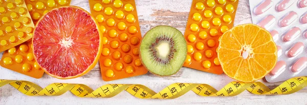 Natural fruits, centimeter and pills, slimming, choice between healthy nutrition and supplements
