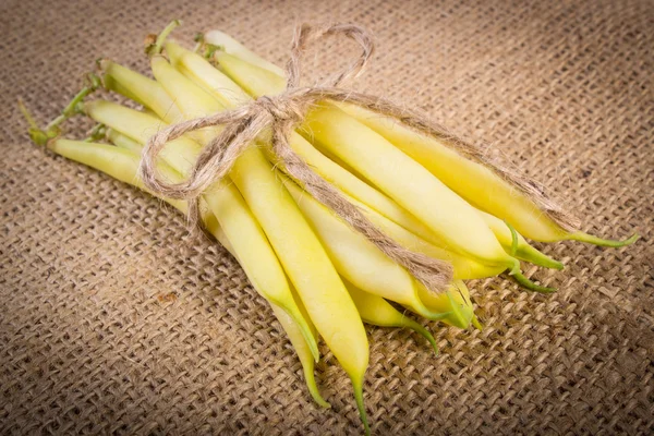 Stack of yellow beans on jute canvas, healthy food