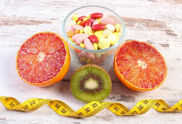 Natural fruits, centimeter and pills, slimming, choice between healthy nutrition and medical supplements