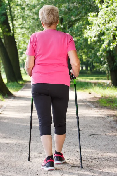 Elderly senior woman practicing nordic walking, sporty lifestyles in old age