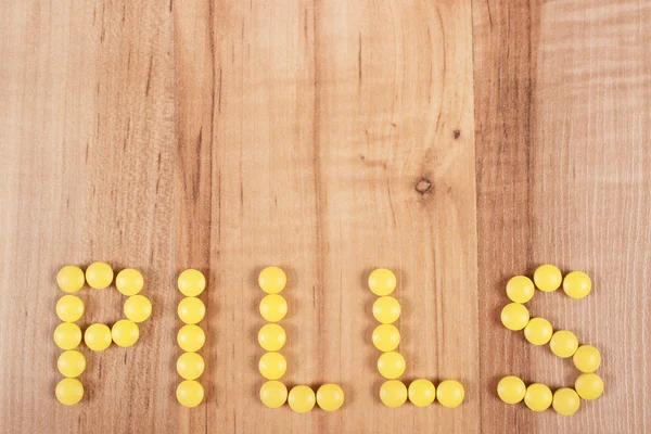 Inscription pills made of yellow medical tablets, health care concept, copy space for text