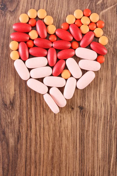 Heart shaped colorful medical pills and capsules, health care concept, copy space for text