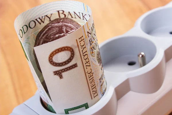 Rolls of polish currency money in electrical power strip, energy costs