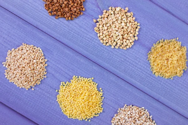 Heap of various groats on wooden boards, healthy food and nutrition