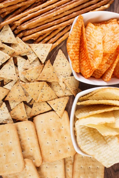 Heap of salted crisps, breadsticks and cookies, concept of unhealthy food