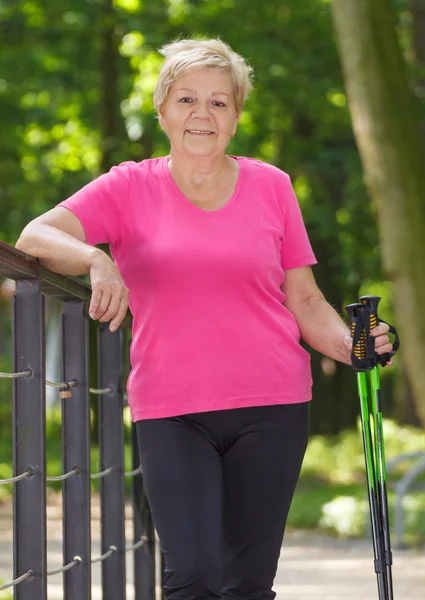 Elderly senior woman practicing nordic walking, sporty lifestyles in old age