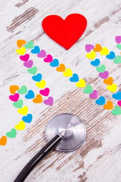 Cardiogram line of paper hearts and stethoscope on wooden background, medicine and healthcare concept